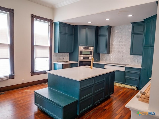 kitchen featuring a sink, decorative backsplash, light countertops, ornamental molding, and dark wood-type flooring