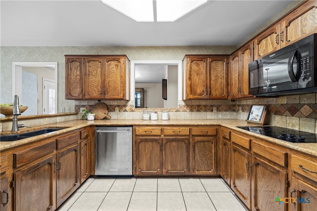 kitchen featuring black appliances, backsplash, sink, and light tile patterned floors