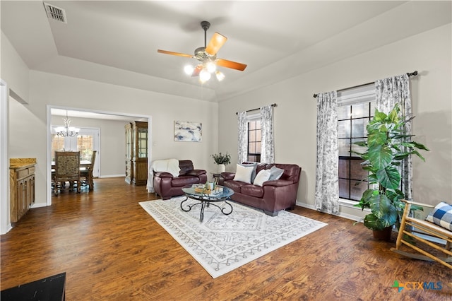 living room with dark hardwood / wood-style floors and ceiling fan with notable chandelier