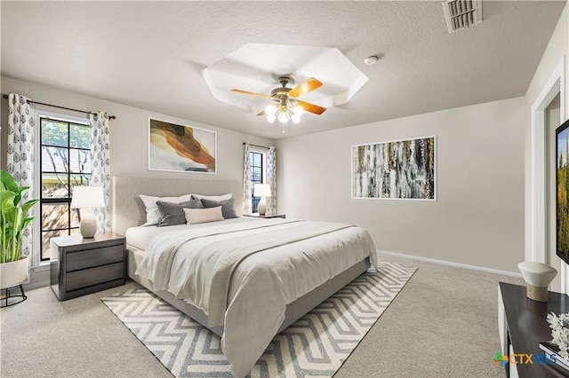 carpeted bedroom featuring a textured ceiling and ceiling fan