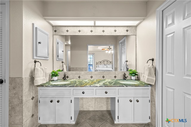 bathroom with tile walls, tile patterned flooring, ceiling fan, and vanity