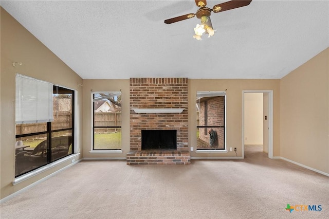 unfurnished living room featuring vaulted ceiling, a brick fireplace, light colored carpet, and a textured ceiling