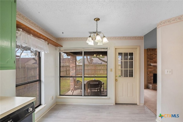 unfurnished dining area featuring a notable chandelier, light hardwood / wood-style flooring, and a textured ceiling