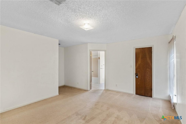 carpeted spare room with a textured ceiling