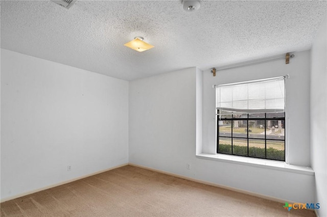 carpeted empty room featuring a textured ceiling