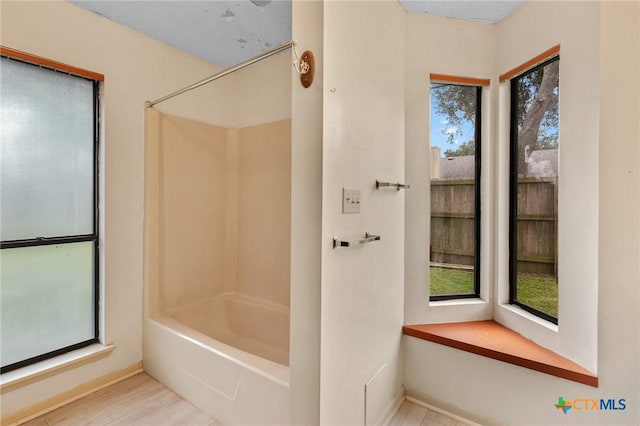 bathroom featuring shower / bath combination, hardwood / wood-style floors, and a wealth of natural light