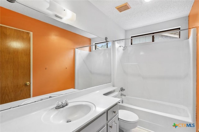 full bathroom featuring toilet, plenty of natural light, bathing tub / shower combination, and a textured ceiling