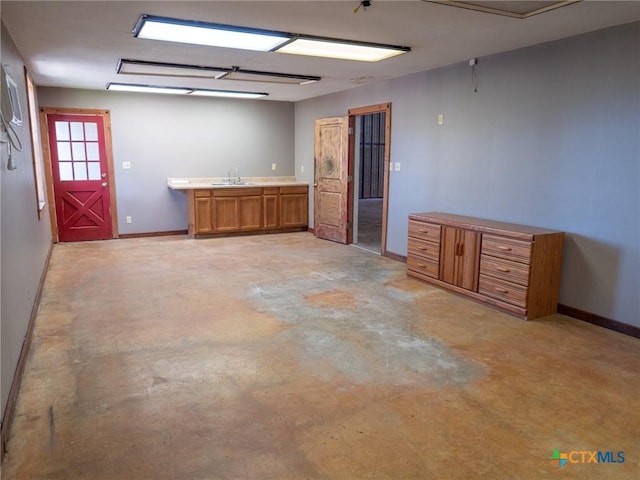 interior space featuring baseboards and a sink