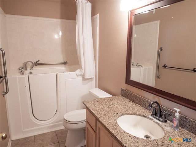 full bathroom with vanity, a bathtub, tile patterned flooring, and toilet