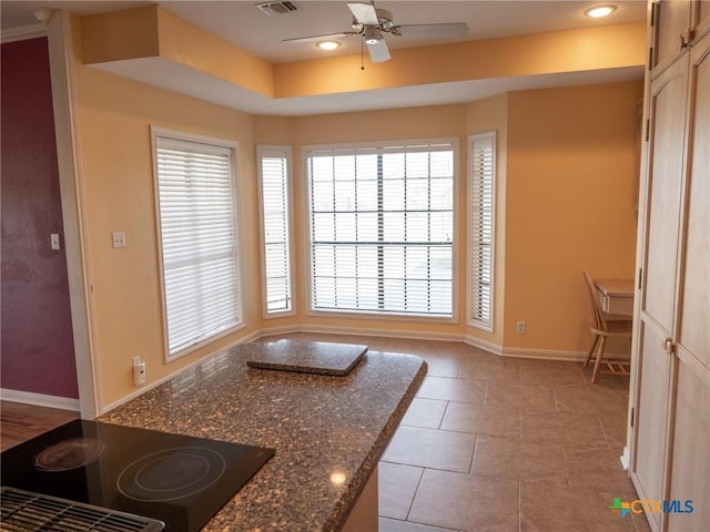 interior space featuring ceiling fan, baseboards, stovetop, recessed lighting, and light tile patterned flooring