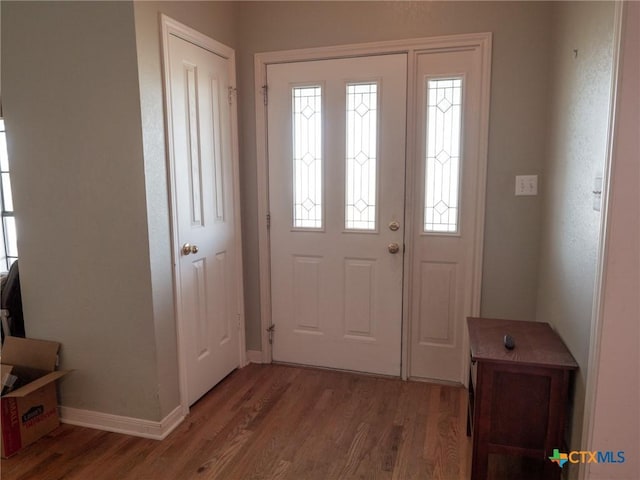 foyer featuring wood finished floors and baseboards