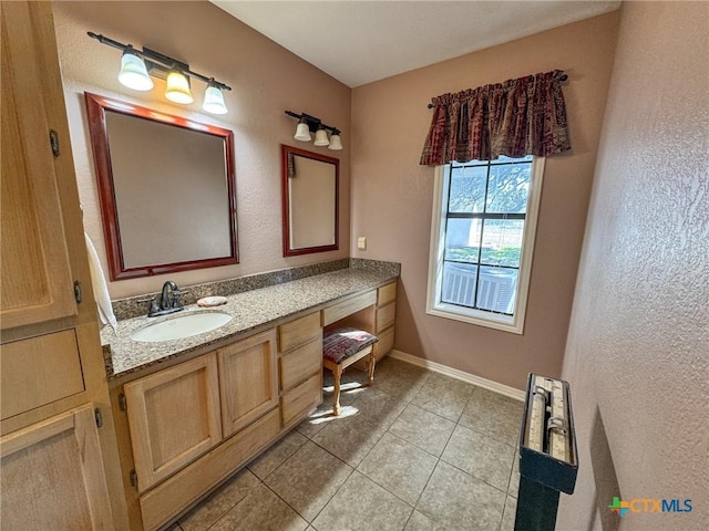 bathroom with tile patterned floors, vanity, and baseboards