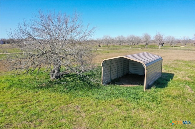 view of yard with a detached carport and a rural view