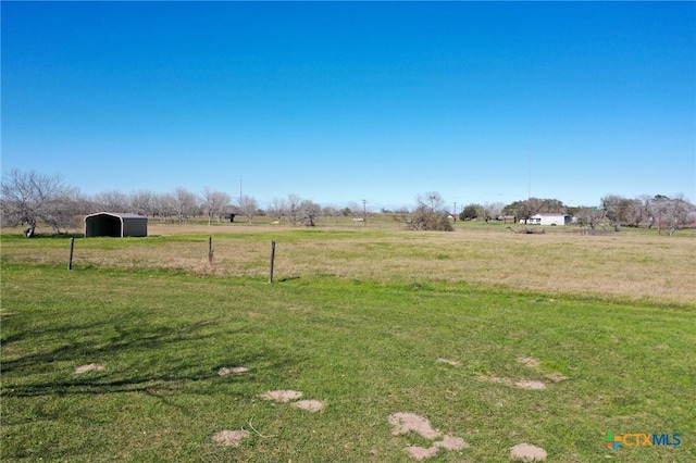 view of yard with a carport and a rural view