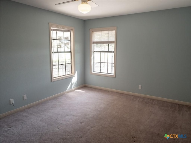 unfurnished room with a ceiling fan, baseboards, and carpet floors