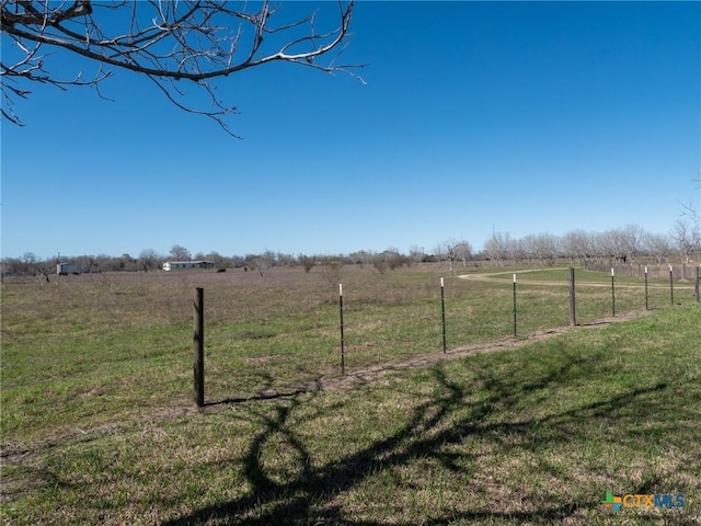 view of yard featuring a rural view and fence