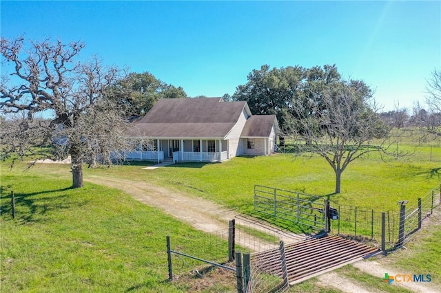 farmhouse-style home with driveway, a gate, a porch, fence, and a front yard