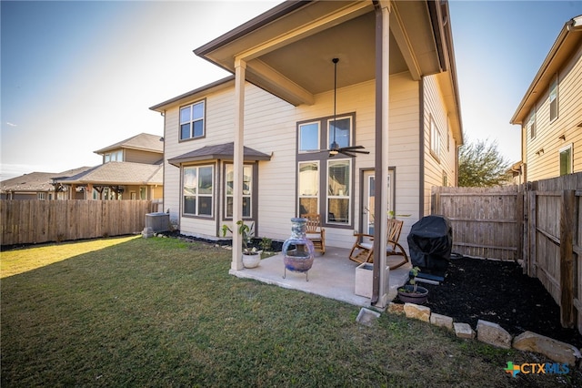 back of house featuring cooling unit, a yard, and a patio