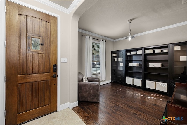 foyer with ornamental molding and a textured ceiling