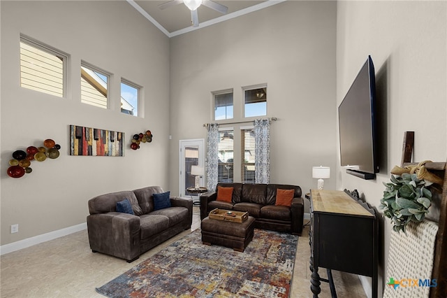 living room featuring ceiling fan, light tile patterned floors, crown molding, and a high ceiling