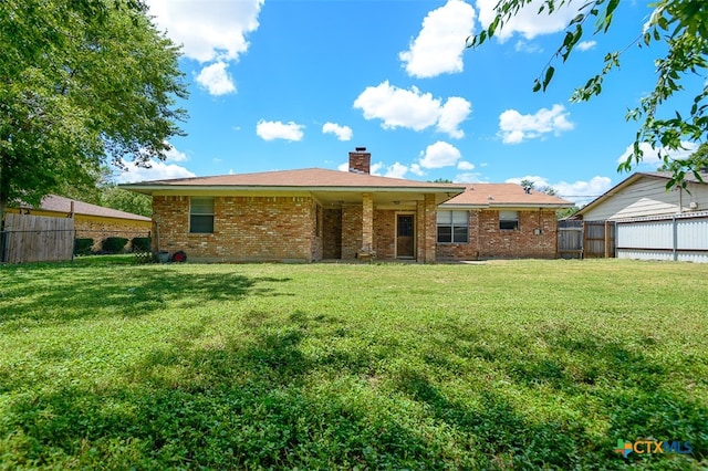 rear view of house featuring a lawn