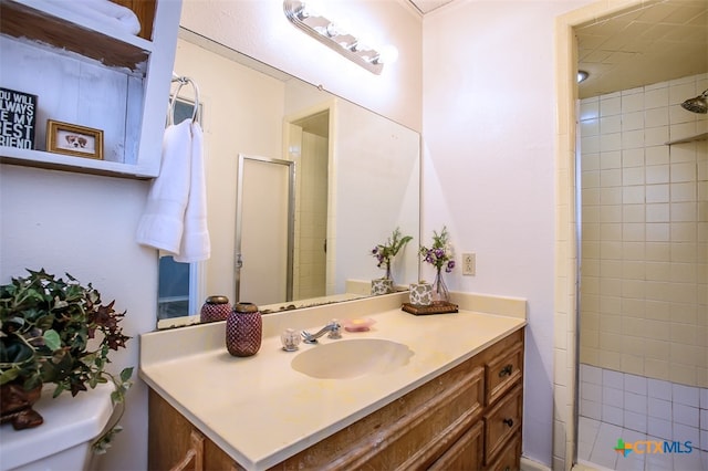 bathroom featuring toilet, vanity, and an enclosed shower