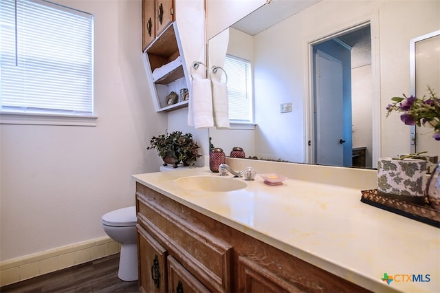 bathroom with toilet, vanity, and hardwood / wood-style floors