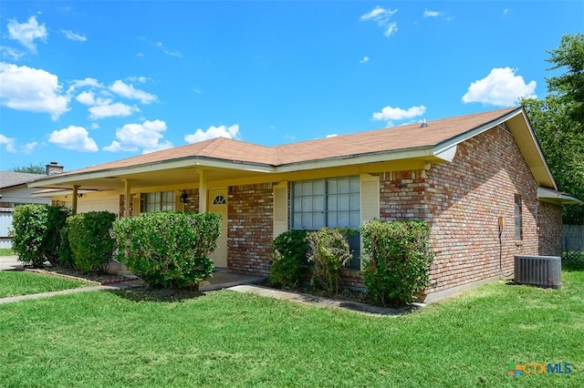 ranch-style house with cooling unit and a front yard