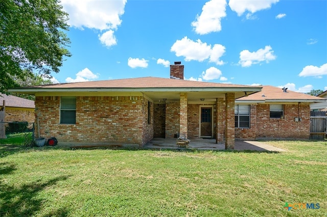 rear view of house featuring a patio and a yard