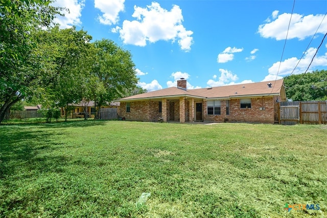 back of property featuring a yard