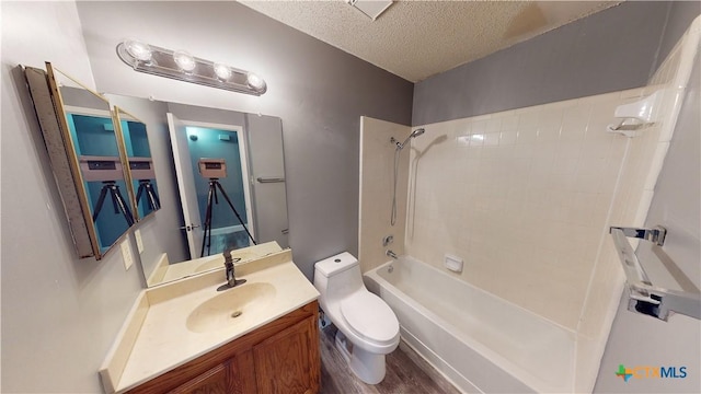 full bathroom featuring toilet, hardwood / wood-style floors, shower / bathing tub combination, a textured ceiling, and vanity