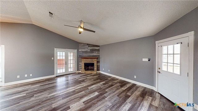 unfurnished living room with vaulted ceiling, dark wood-type flooring, a wealth of natural light, and french doors