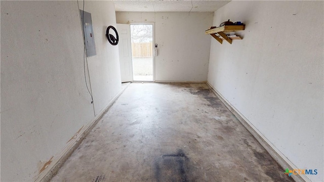 empty room with concrete flooring and electric panel