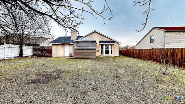 rear view of house featuring a yard