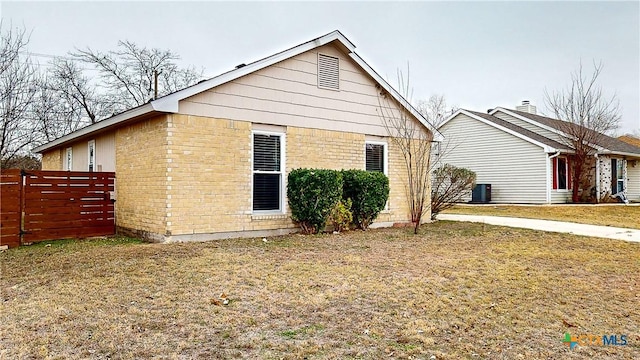 back of house featuring central air condition unit and a yard