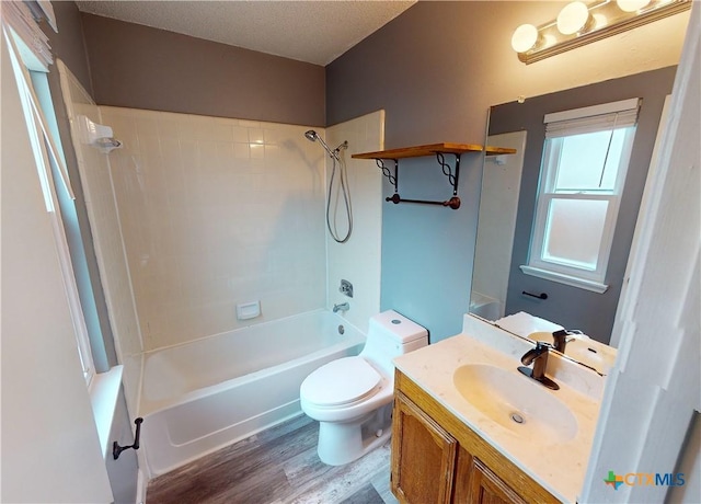 full bathroom with hardwood / wood-style floors, shower / bathing tub combination, a textured ceiling, vanity, and toilet