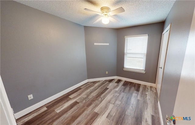 unfurnished room with a textured ceiling, ceiling fan, and wood-type flooring