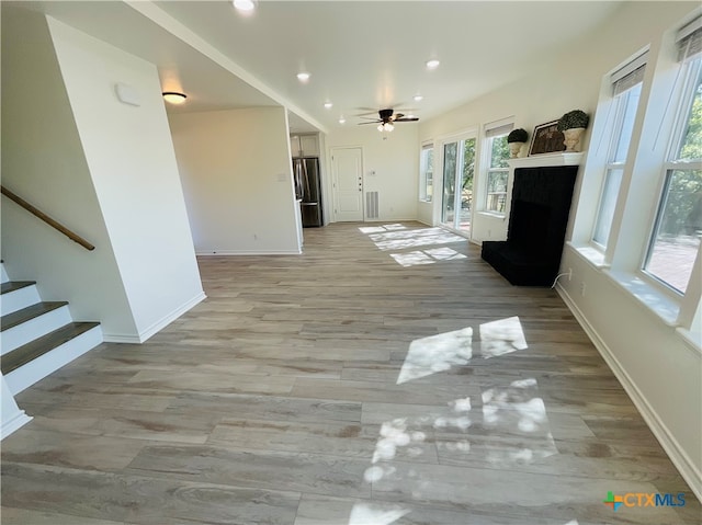 unfurnished living room featuring light hardwood / wood-style floors and ceiling fan