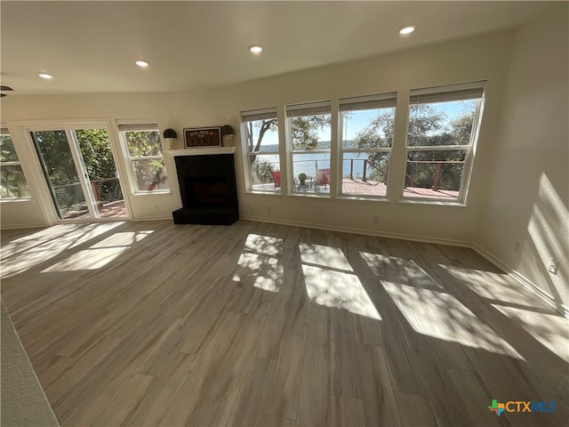 unfurnished living room with dark wood-type flooring and a healthy amount of sunlight