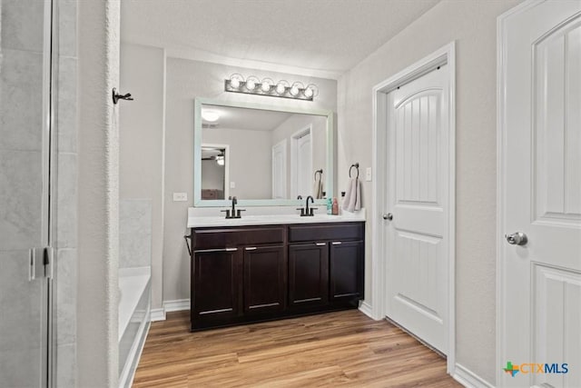 bathroom featuring vanity, hardwood / wood-style floors, and a textured ceiling