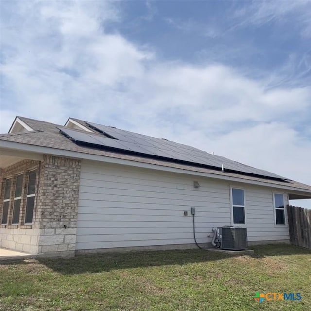 3805 Flat Rock Mountain Dr, Killeen, TX 76549 - view of home's exterior featuring cooling unit, a yard, fence, solar panels, and an attached garage