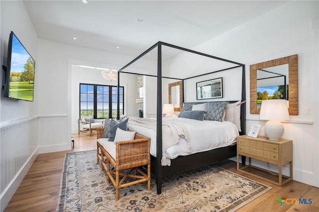 bedroom featuring a wainscoted wall, recessed lighting, an inviting chandelier, and wood finished floors