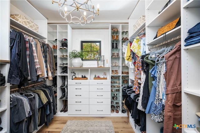 walk in closet featuring an inviting chandelier and wood finished floors