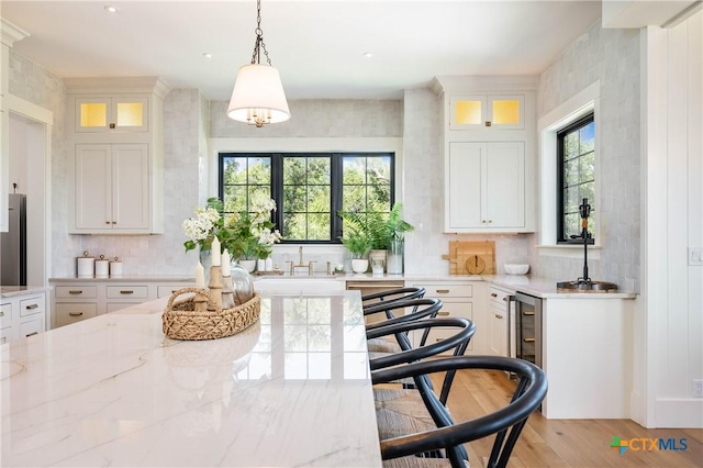 kitchen featuring decorative backsplash, white cabinets, and a sink