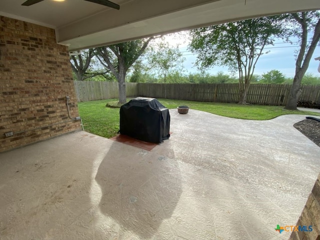 406 Windy Way Dr, Victoria, TX 77904 - fenced backyard featuring a grill, a patio area, and a ceiling fan