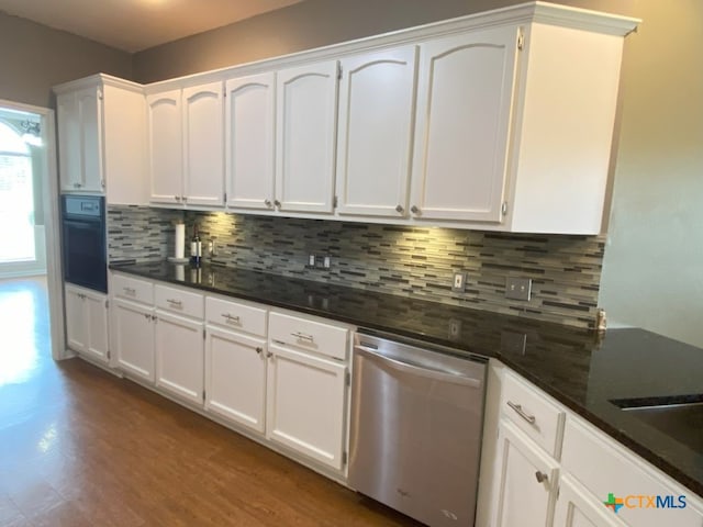406 Windy Way Dr, Victoria, TX 77904 - kitchen featuring stainless steel dishwasher, black oven, and white cabinetry