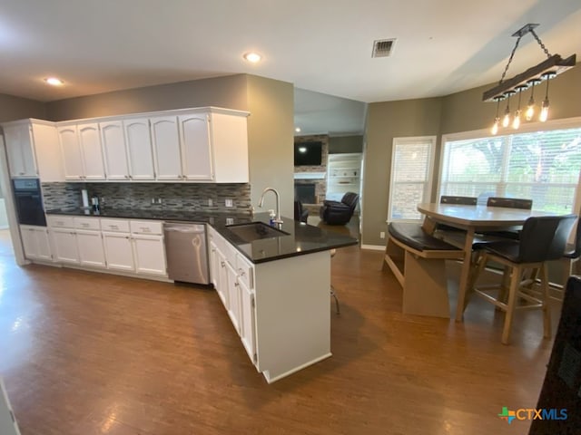 406 Windy Way Dr, Victoria, TX 77904 - kitchen with dishwasher, a peninsula, backsplash, white cabinets, and dark wood-type flooring