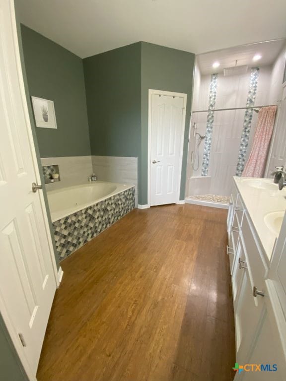 406 Windy Way Dr, Victoria, TX 77904 - bathroom with wood finished floors, a bath, tiled shower, and double vanity