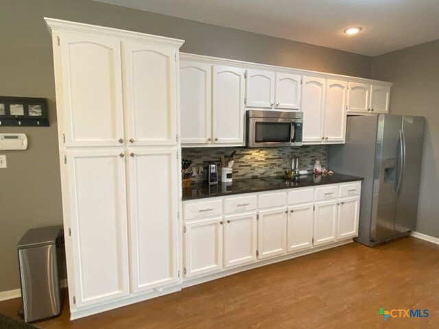 406 Windy Way Dr, Victoria, TX 77904 - kitchen with appliances with stainless steel finishes, white cabinetry, dark countertops, tasteful backsplash, and recessed lighting