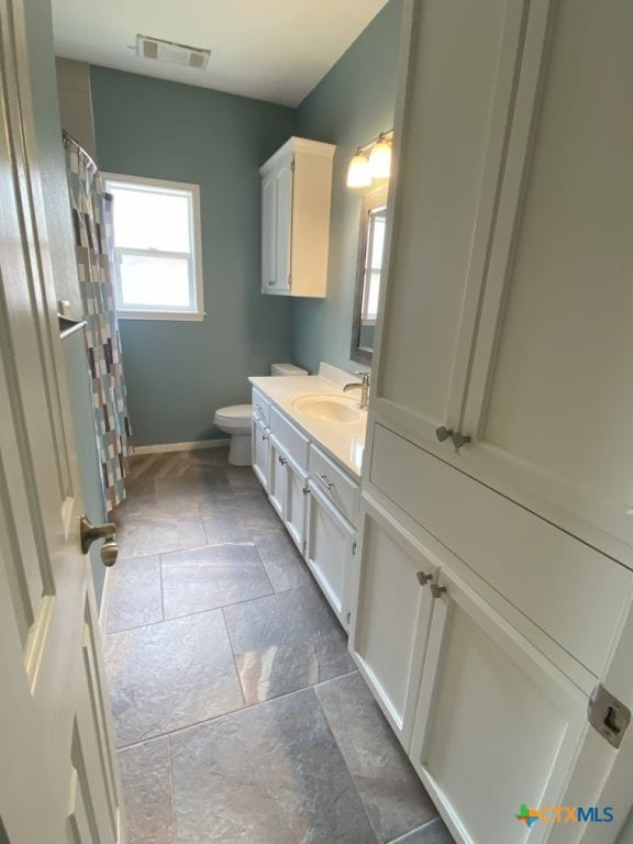 406 Windy Way Dr, Victoria, TX 77904 - bathroom featuring stone tile flooring, vanity, and curtained shower